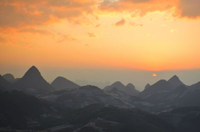 Scenic view of mountains against orange sky