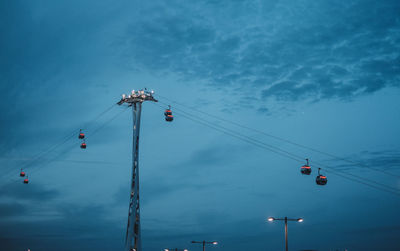 Low angle view of overhead cable car against blue sky