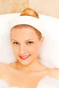 Close-up portrait of young woman taking bubble bath in bathtub