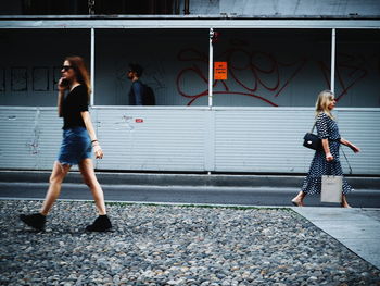 Full length of woman standing against wall