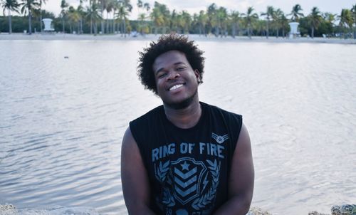 Portrait of smiling young man standing in water