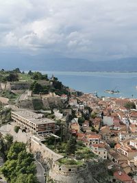 High angle view of townscape by sea against sky