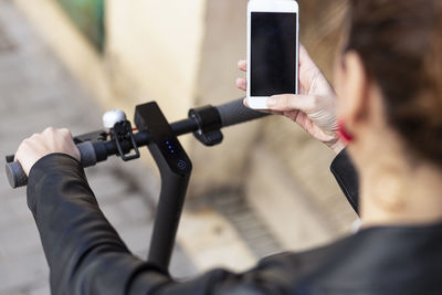 High angle view of woman using phone on electric push scooter