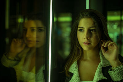 Young woman looking through glass window