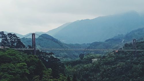 Bridge over mountain against sky