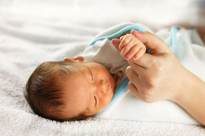 Close-up of baby girl lying on bed