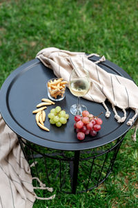 A glass of white wine with appetizers on the table.