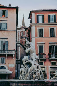 Statue against buildings in city