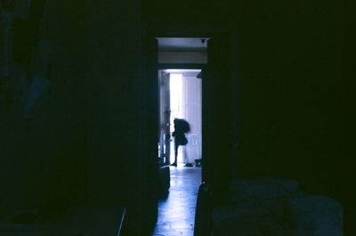 Silhouette man standing at entrance of building