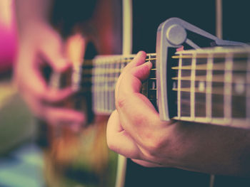 Midsection of guitarist playing at music concert