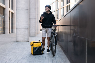 Rear view of man riding push scooter