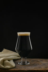 An glass of craft dark stout beer with chocolate flavor