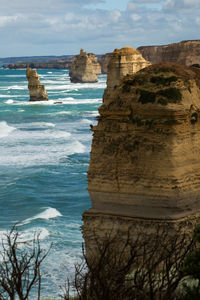 Scenic view of sea by cliff against sky