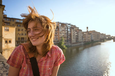 Young woman over arno river at ponte vecchio in city