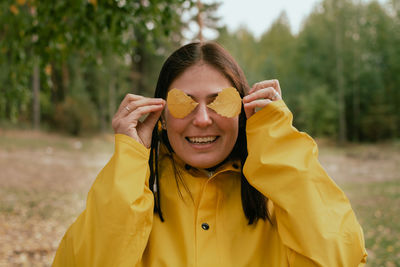 Cheerful young woman in a yellow raincoat and yellow boots poses for the camera. person