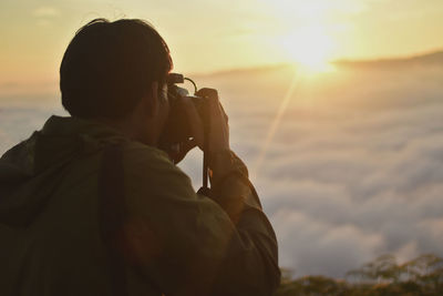 Man photographing at sunset