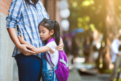 Girl embracing mother outdoors