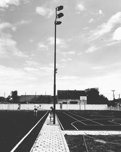 Street by railroad tracks against sky