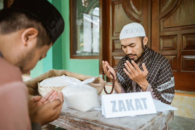 Young men praying together to allah in mosque