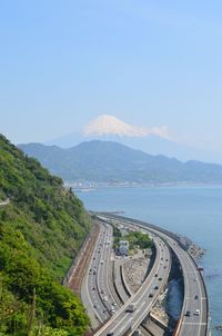 High angle view of highway by mountains against sky