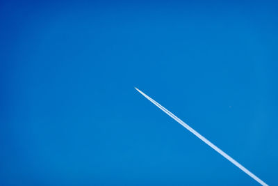 Low angle view of airplane flying against blue sky