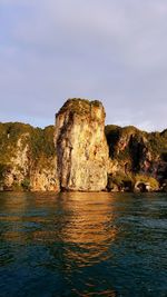 Rock formations by sea against sky