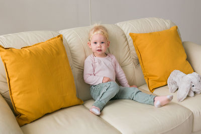 Portrait of woman sitting on bed at home