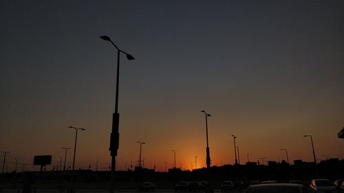 Low angle view of silhouette street lights against sky during sunset