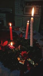 Close-up of lit tea light candles in darkroom