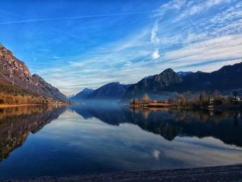 Scenic view of lake and mountains against blue sky