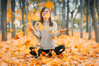 Portrait of young woman standing in park during autumn