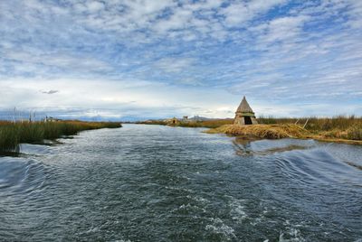 Scenic view of river by building against sky