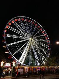 Illuminated ferris wheel against sky at night