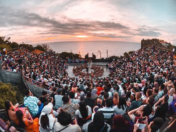 Group of people in town square during sunset