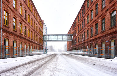 Road amidst buildings in city against clear sky