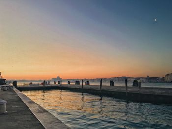 Scenic view of river against clear sky during sunset