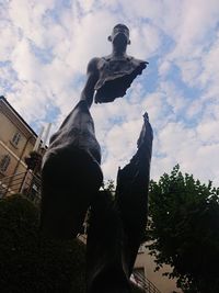 Low angle view of statue against building and sky