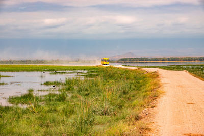 A vehicle on a dirt road in the savannah grassland landscapes of amboseli national park in kenya