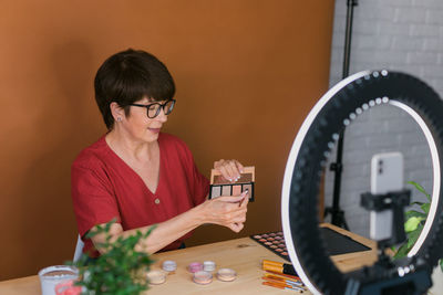 Senior woman filming make-up vlog