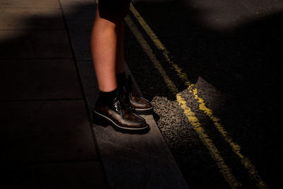 Low section of woman standing on road