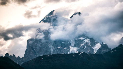 Low angle view of snowcapped mountains against sky
