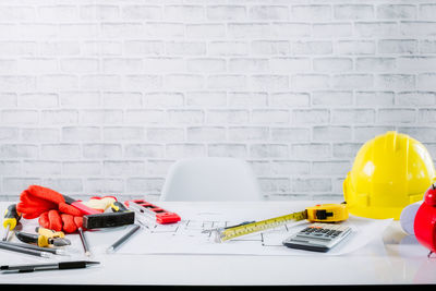Close-up of various flowers on table against wall