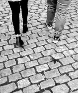 Low section of people standing on cobblestone street