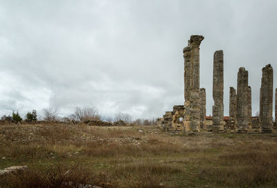 Abandoned ruins on field against sky