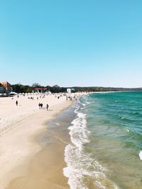 People on beach against clear sky