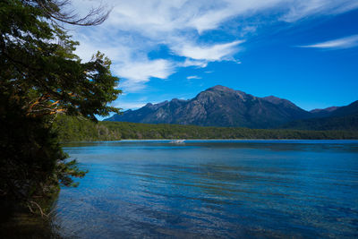 Scenic view of lake and mountains against blue sky