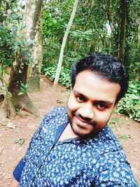 Portrait of smiling young man in forest