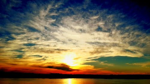 Scenic view of sea against dramatic sky during sunset