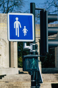 Close-up of road sign against blue sky