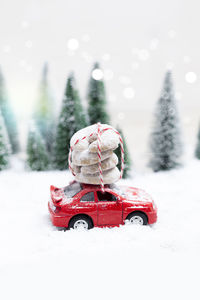 Christmas tree and toy car on snow